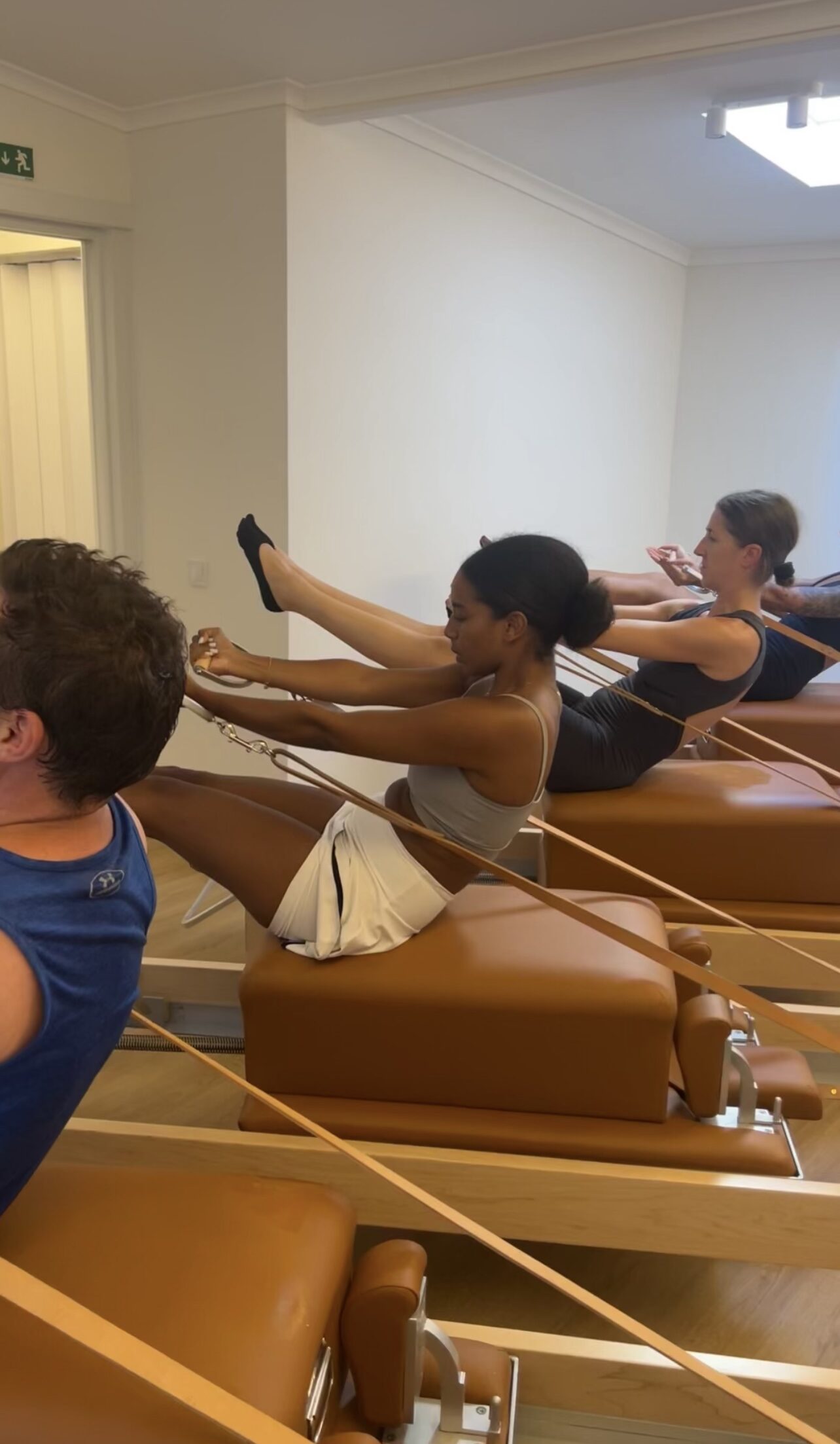 Students working together on the reformers during a group class at Soul Circle